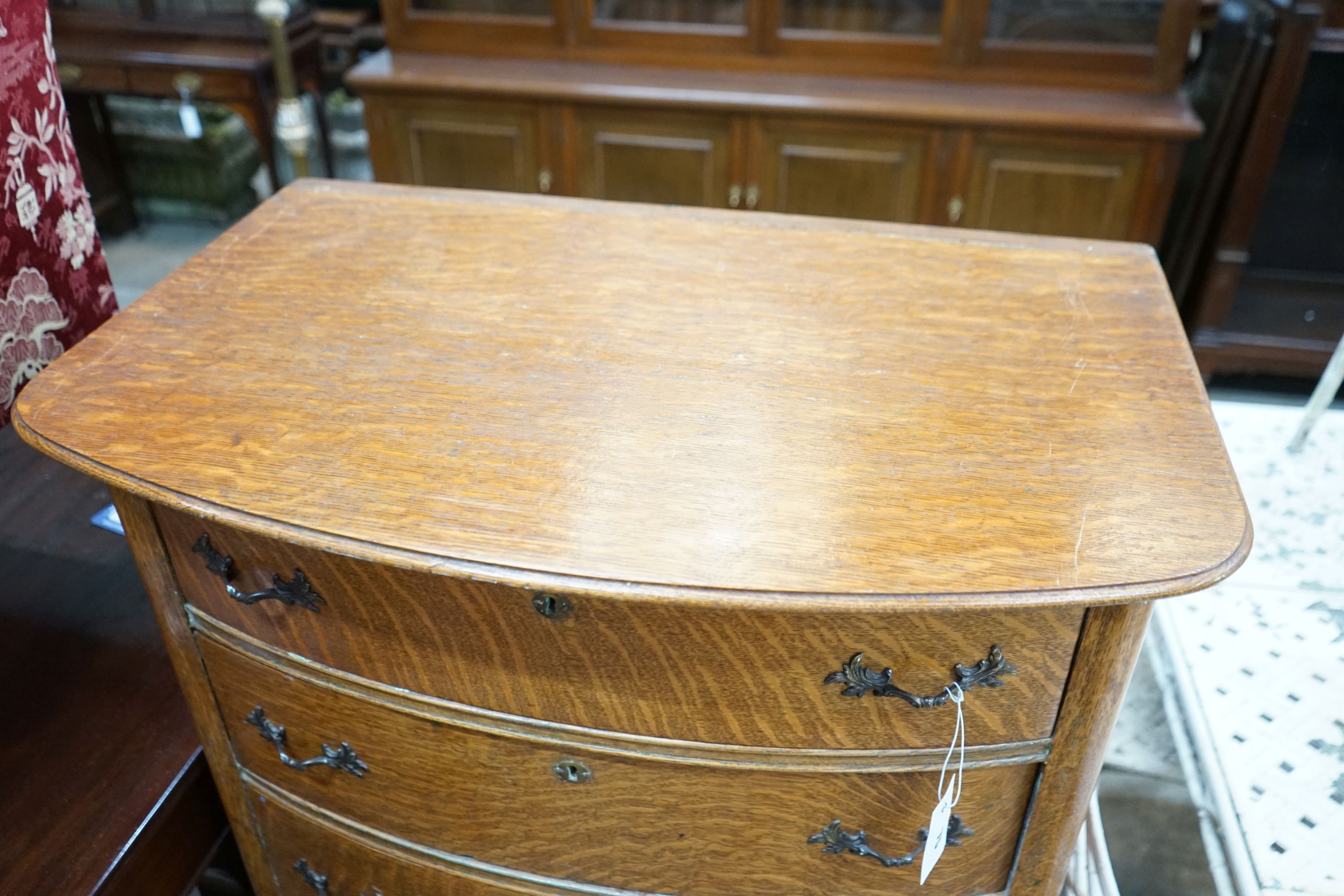 An early 20th century oak bow front tall chest, width 76cm, depth 49cm, height 123cm